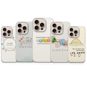 Pode incluir: Cinco capas de telefone com vários designs e citações. Uma capa tem uma ferradura e o texto "YOU ARE LUCKY". Outra diz "NO RAIN NO FLOWERS". Outras capas têm as frases "HAPPINESS COMES IN WAVE IT WILL FIND YOU AGAIN" e "the sun will rise and we will try again".