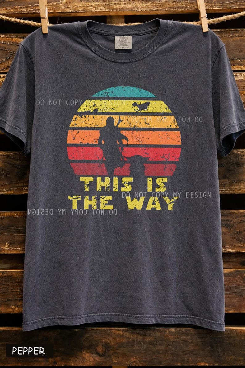 Vintage distressed retro sunset graphic featuring a galactic warrior silhouette with the quote “This Is The Way” on a dark t-shirt design in bootleg vintage style.