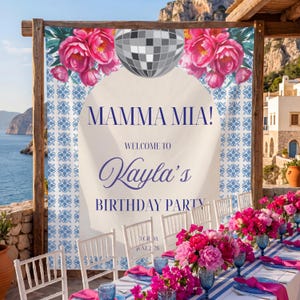 May include: A party banner with the words "MAMMA MIA!" and "Welcome to Kayla's Birthday Party" in a decorative font. The banner features a disco ball, pink flowers, and a blue and white tile pattern. A long table is set with blue and white striped linens, pink napkins, and floral centerpieces.