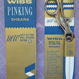 May include: Vintage WISS pinking shears with a silver blade and handles, displayed with their original blue and gold packaging. The packaging features the text "PINKING SHEARS" and "EASY CUTTING BALL BEARING ACTION."