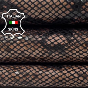 Puede incluir: Primer plano de tres piezas apiladas de cuero marrón con un patrón negro similar a una red. El cuero tiene una textura de piel de serpiente y un brillo sutil. El logotipo de Italian Skins es visible.