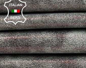 May include: Close-up of a stack of four pieces of gray leather with a subtle pink shimmer. The leather has a textured, slightly grainy surface. The label "ITALIAN LEATHER" is visible on the top piece of leather.