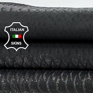 Può includere: Primo piano di tre pezzi di pelle nera impilati con diverse trame. Lo strato superiore ha un motivo a pois, lo strato intermedio ha un motivo strutturato e lo strato inferiore ha un motivo a righe. Il logo Italian Skins è visibile.