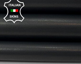 May include: Close-up of stacked black leather sheets. The leather has a smooth, slightly shiny surface. The image includes the "Italian Skins" logo in the upper left corner.