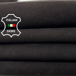 May include: A folded piece of dark brown leather with a smooth, matte texture. A white shield-shaped emblem is visible on the left side, featuring the text ITALIAN SKINS with a small Italian flag icon centred within the design.