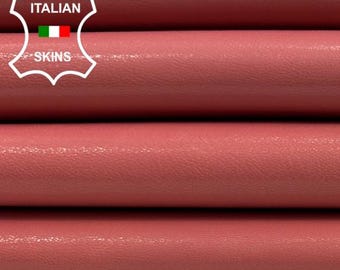 Puede incluir: Cuatro rollos de cuero rosa, apilados uno encima del otro. El cuero tiene un acabado liso y brillante. La etiqueta "ITALIAN SKINS" es visible en la esquina superior izquierda de la imagen.