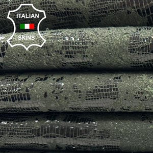 Può includere: Cinque pezzi di pelle verde scuro con un motivo goffrato nero. La pelle è arrotolata e impilata l'una sull'altra. L'etichetta "ITALIAN SKINS" è visibile nell'angolo in alto a sinistra dell'immagine.