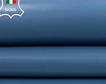 May include: Close-up of a stack of three pieces of blue leather. The leather is smooth and has a slight sheen. The leather is labeled "ITALIAN SKINS".
