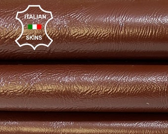 May include: Three rolls of brown leather, stacked on top of each other. The leather has a textured surface. The label "ITALIAN SKINS" is visible on the top roll.