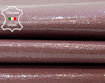 Puede incluir: Primer plano de una pila de tres piezas de cuero de color malva. El cuero tiene una superficie texturizada, granulada y un acabado brillante. El cuero está etiquetado como "ITALIAN LEATHER SKINS".