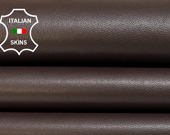 May include: Three rolls of dark brown leather, stacked on top of each other. The leather has a smooth, slightly textured surface. The label "ITALIAN SKINS" is visible in the top left corner of the image.