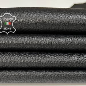May include: Close-up of a stack of black leather, showing the textured surface. The leather is labeled "ITALIAN SKINS".