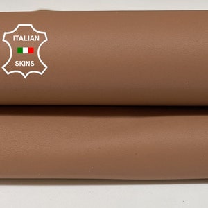 May include: Two pieces of brown leather are stacked on top of each other. The leather is smooth and has a slight sheen. The leather is labeled "ITALIAN SKINS".