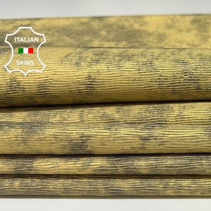 May include: Close-up of a stack of yellow leather with a black marbled pattern. The leather has a textured surface and is labeled "ITALIAN SKINS".