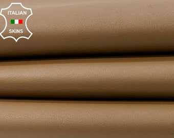 May include: Three rolls of brown leather, stacked on top of each other. The leather is smooth and has a slight sheen. The label "ITALIAN SKINS" is visible on the top roll.