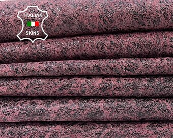 May include: Close-up of a stack of pink leather with a black speckled pattern. The leather is folded and arranged in a row. The label "ITALIAN SKINS" is visible in the top left corner.