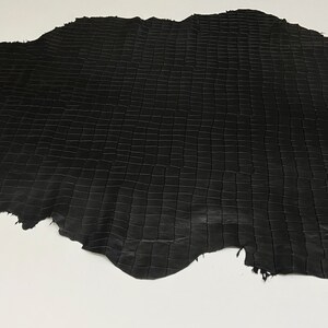May include: Black leather with a grid pattern. The leather is textured and has a slightly rough surface. The leather is labeled "ITALIAN SKINS".