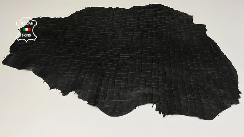 May include: Black leather with a grid pattern. The leather is textured and has a slightly rough surface. The leather is labeled "ITALIAN SKINS".