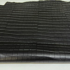 May include: Black leather with a square embossed pattern. The leather is folded in half and has a label that reads "ITALIAN SKINS" with a small Italian flag.