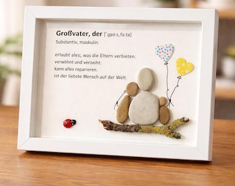 May include: A white framed wall art piece featuring a pebble art design of three figures sitting on a branch. The text reads: Großvater, der ['gɡo:s,fa:ta] Substantiv, maskulin. erlaubt ales;, was die Eltern verbieten: verwöhnt und verzeiht: kann alles reparieren: ist der liebste Mensch auf der Welt. Two colorful heart balloons and a ladybug are included.