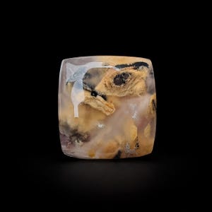 May include: A square-shaped polished gemstone cabochon with rounded corners. The stone features a translucent, milky white base with prominent inclusions of tan, beige, and dark brown mineral patterns that resemble organic, cloud-like formations.