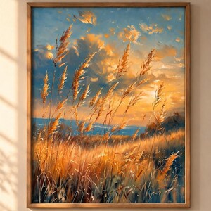May include: A framed rectangular wall art print depicting a field of tall golden grasses under a sunset sky. The painting features warm orange and yellow hues blending into a deep blue horizon, with textured brushstrokes capturing the light.