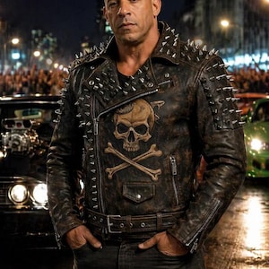 Könnte beinhalten: Braune Lederjacke mit silbernen Stacheln an Schultern und Kragen. Die Jacke hat ein Totenkopf- und gekreuzte Knochen-Motiv und einen Gürtel. Die Person trägt eine schwarze Jeans.