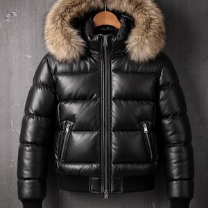 May include: Black puffer jacket with a fur-trimmed hood. The jacket has a zip-up front, two zipped pockets, and ribbed cuffs. The jacket is hanging on a wooden hanger. The jacket is approximately 63 cm long.