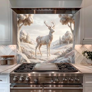 May include: A white marble-like mural of a deer standing in a winter landscape, framed by a kitchen range hood. The artwork features a deer with large antlers, trees, and rolling hills. The kitchen has white cabinets and a stainless steel range.