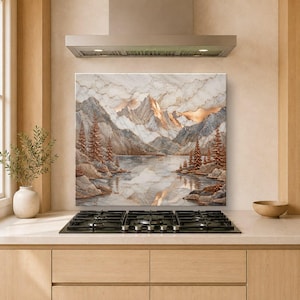 May include: A square wall art piece featuring a landscape painting of jagged mountains, a calm lake, and evergreen trees. The artwork uses a palette of white, grey, and copper tones, with a marble-like texture throughout the sky and mountain peaks.