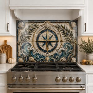May include: A rectangular decorative backsplash panel featuring a central nautical compass rose in blue and gold, surrounded by sculpted relief details of ocean waves, seashells, and olive branches in shades of cream, blue, and muted green.