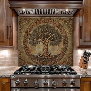 May include: A decorative kitchen backsplash featuring a tree of life design. The artwork is framed by a Celtic knot border and is rendered in shades of brown, gold, and green. The backsplash is installed above a stainless steel gas range.