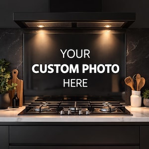 Peut inclure: Cuisine moderne avec hotte noire et table de cuisson à gaz. Le fond de la hotte affiche le texte "YOUR CUSTOM PHOTO HERE" en blanc. Ustensiles en bois et planche à découper visibles.