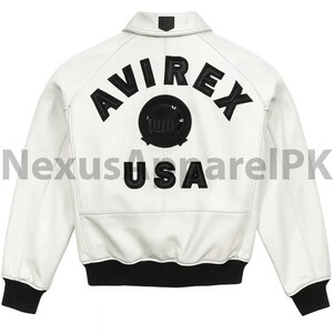 Puede incluir: Chaqueta de cuero blanca con pu&ntilde;os y dobladillo negros. La parte trasera presenta la palabra "AVIREX" en letras negras sobre un emblema circular y la palabra "USA".