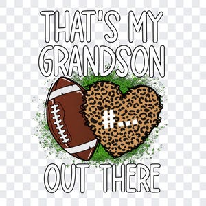 May include: A graphic design featuring the text THAT'S MY GRANDSON OUT THERE in white with black outlines. The image includes a brown football with white laces next to a heart shape with a brown and black leopard print pattern on green grass.