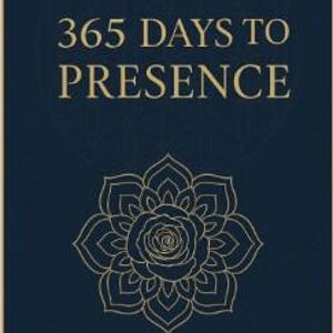 May include: A navy blue journal with the text "365 DAYS TO PRESENCE" in gold lettering. A gold floral design is below the text. The journal has a light tan spine and a geometric pattern on the cover.
