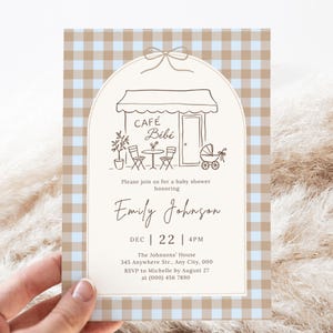 Peut inclure: Une carte d'invitation rectangulaire pour une baby shower avec une bordure à carreaux bleu clair et beige. Le centre présente une arche crème avec un dessin au trait marron d'un café, d'un landau et le texte CAFÉ BÉBÉ, Emily Johnson, Dec 22, 4PM.