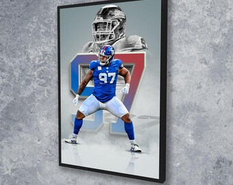 May include: Framed artwork featuring a football player in a blue uniform with the number 97. The player is in a stance, with a larger image of a helmeted player in the background. The artwork has a black frame.