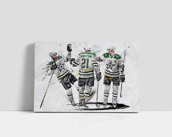 May include: Canvas art print featuring three hockey players in action, rendered in a watercolor style. The players wear white, green, and black uniforms with the number 21 visible. The artwork has a dynamic, energetic feel with paint splatter effects.