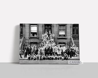 May include: A monochrome photograph showing a large group of people posing on the steps of a building. The group includes men, women, and children, all in formal attire. The building has windows and a door.