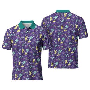 May include: Purple polo shirt with a green collar and a pattern of yellow and blue cartoon characters. The shirt has short sleeves and a button-down collar. A second shirt is visible in the background.