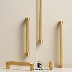 May include: A collection of gold-colored cabinet hardware, including long bar pulls, short pulls, and a knob. The hardware has a textured, dotted pattern and is displayed against a neutral background. The Modern Brass Home Hardware logo is visible.