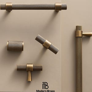 May include: A collection of brass cabinet hardware, including a long bar pull, a cylindrical knob, and several T-bar and angled pulls. The hardware has a textured, diamond-patterned surface and is displayed against a neutral background. The logo "Modern Brass Home Hardware" is visible.