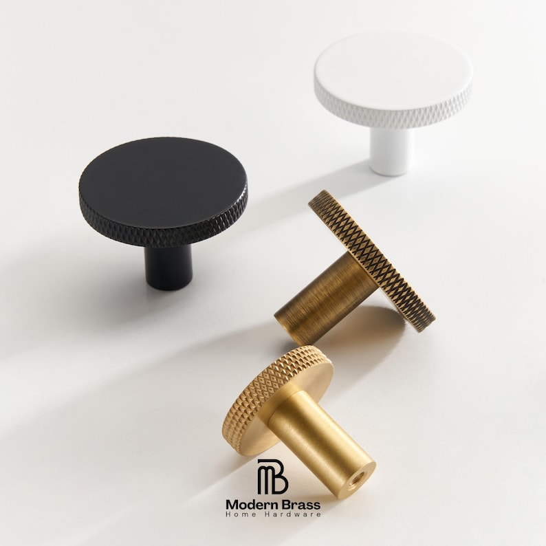 Round flat-top knurled knobs in white, black, gold, and antique brass finishes.