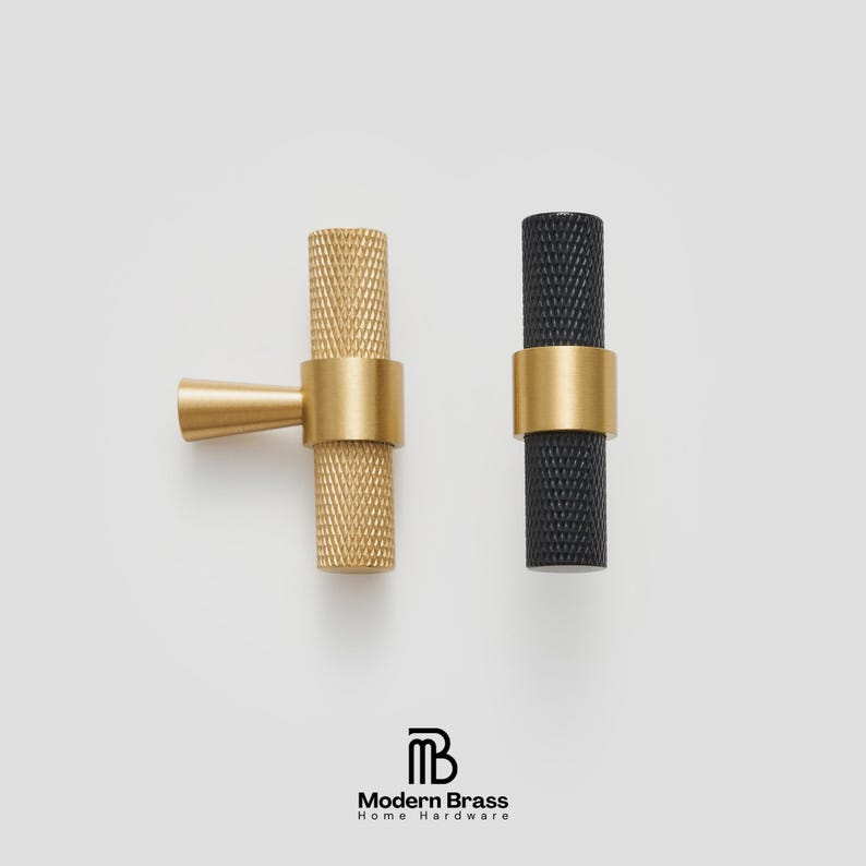 Modern fluted brass knobs and cylindrical handles for high-end kitchen cabinetry.