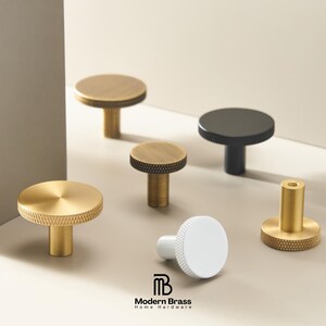 Textured brass drawer pulls featuring a diamond-cut grip and sleek square mounting bases.