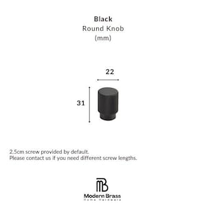 Architectural black hardware set including long appliance pulls and small drawer knobs.