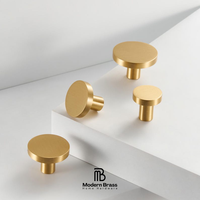 Modern gold disc-shaped knobs for kitchen cabinets, providing a sleek and tactile hardware upgrade.