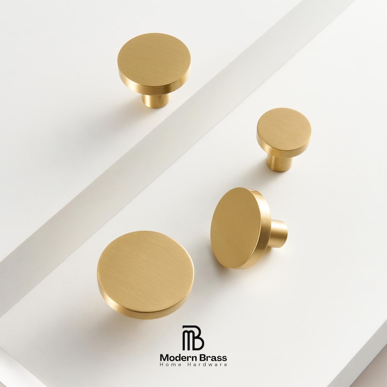 Luxury gold round knobs in multiple sizes featuring a flat top and a soft brushed finish.