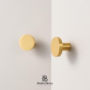 Close-up of modern gold circular knobs made of high-quality solid brass for furniture or cabinets.